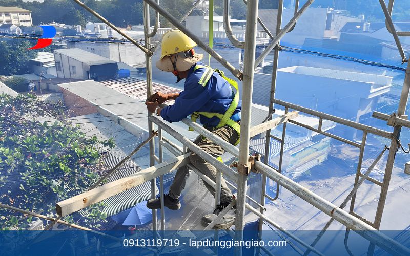 Công nhân đang thao tác lắp dựng giàn giáo dưới sự giám sát của cán bộ an toàn.